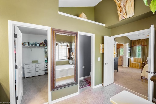 full bath featuring high vaulted ceiling, toilet, baseboards, a garden tub, and tile patterned floors