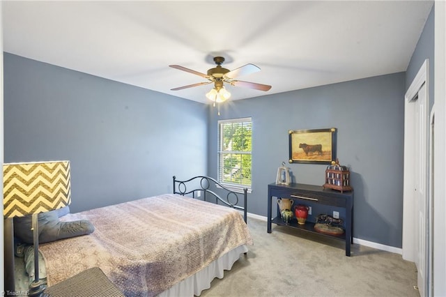 bedroom featuring light carpet, baseboards, a closet, and a ceiling fan