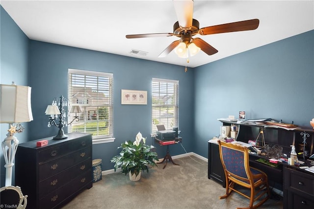 carpeted home office with ceiling fan and baseboards