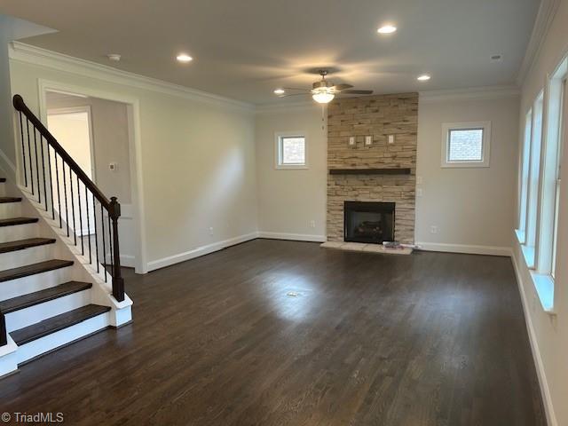 unfurnished living room featuring dark wood-type flooring, ornamental molding, and ceiling fan