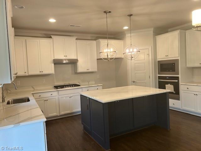 kitchen featuring wall oven, under cabinet range hood, stainless steel microwave, stovetop, and a sink