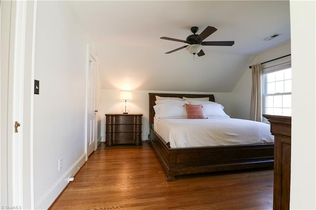 unfurnished bedroom with visible vents, ceiling fan, baseboards, lofted ceiling, and wood finished floors