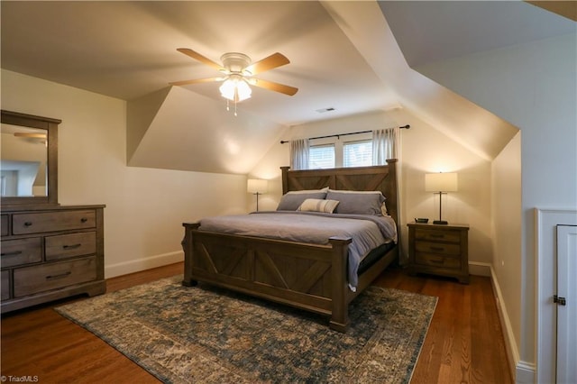 bedroom with vaulted ceiling, visible vents, baseboards, and wood finished floors