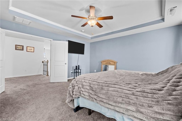 carpeted bedroom featuring ceiling fan, crown molding, and a raised ceiling