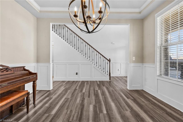 entryway featuring a wealth of natural light, ornamental molding, and a notable chandelier