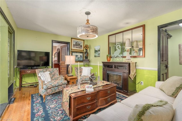 238 Maple St, King, NC 27021 - living room featuring wood finished floors, a wainscoted wall, and a glass covered fireplace