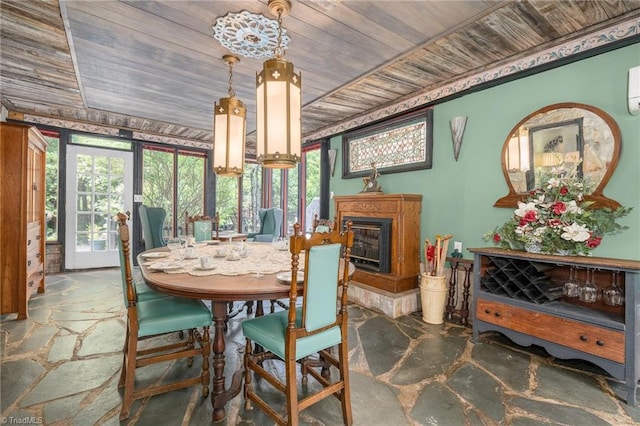 238 Maple St, King, NC 27021 - dining space with wood ceiling, stone floors, a wall mounted air conditioner, and a glass covered fireplace
