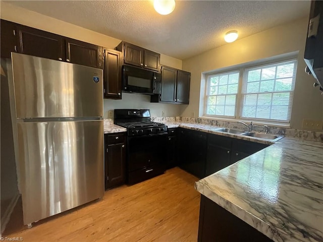 2 Whispering Ct, Greensboro, NC 27407 - kitchen featuring black appliances, a sink, a textured ceiling, light wood-type flooring, and light countertops