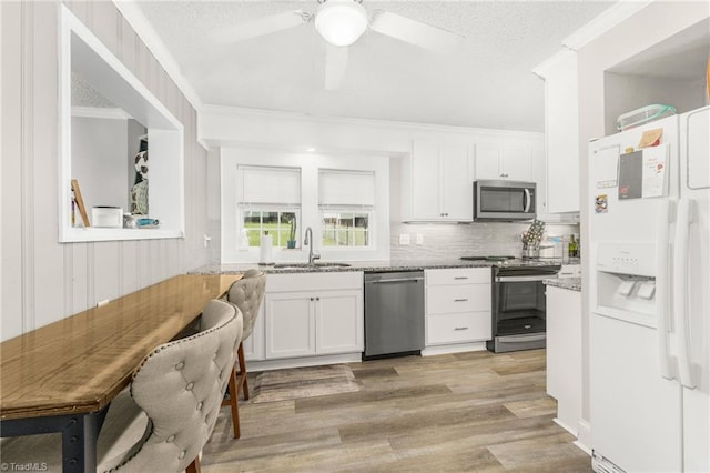 4814 Merrimac St, Winston-Salem, NC 27105 - kitchen featuring stainless steel appliances, white cabinetry, light wood-style flooring, ornamental molding, and light stone countertops