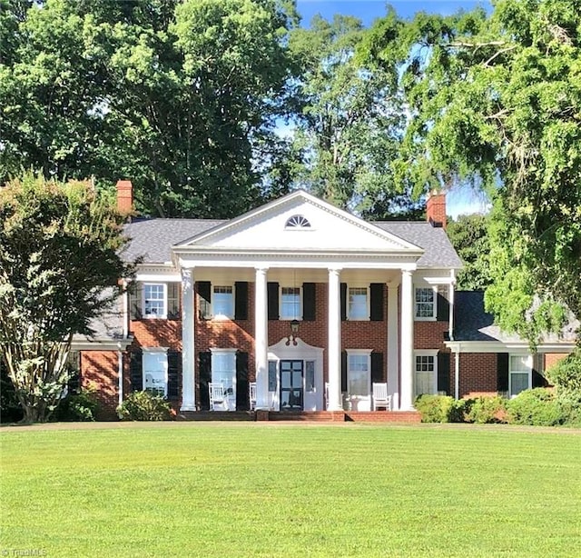 greek revival inspired property with a front yard