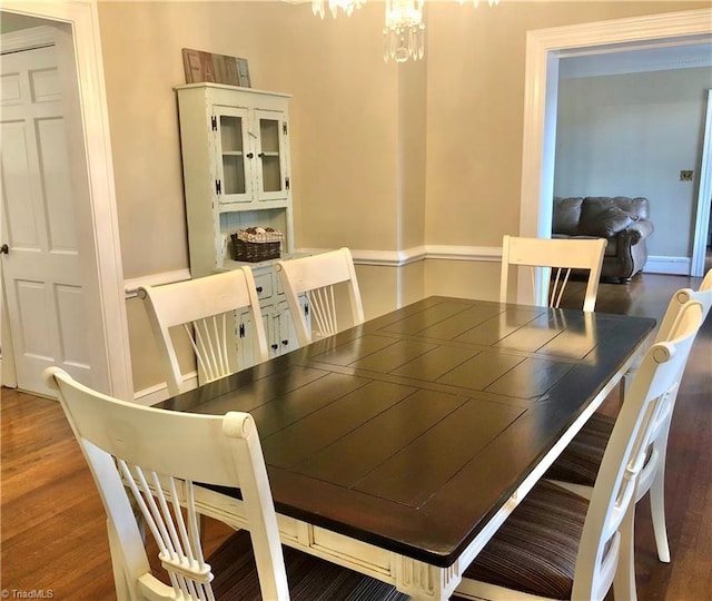 dining space featuring a notable chandelier and dark hardwood / wood-style floors