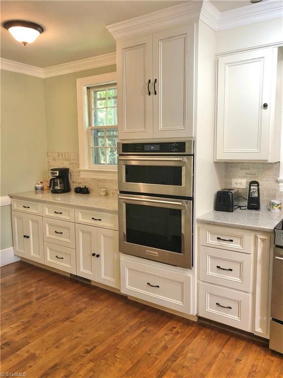 kitchen with backsplash, double oven, and dark hardwood / wood-style floors