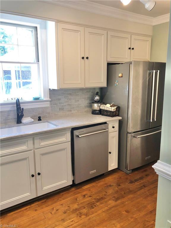 kitchen featuring white cabinets, appliances with stainless steel finishes, dark hardwood / wood-style floors, and tasteful backsplash