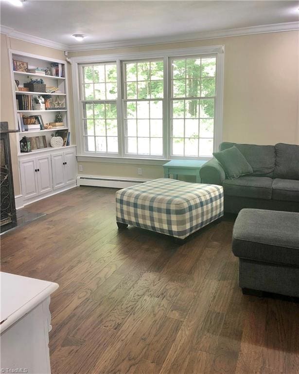 living room with a baseboard radiator, plenty of natural light, dark wood-type flooring, and crown molding