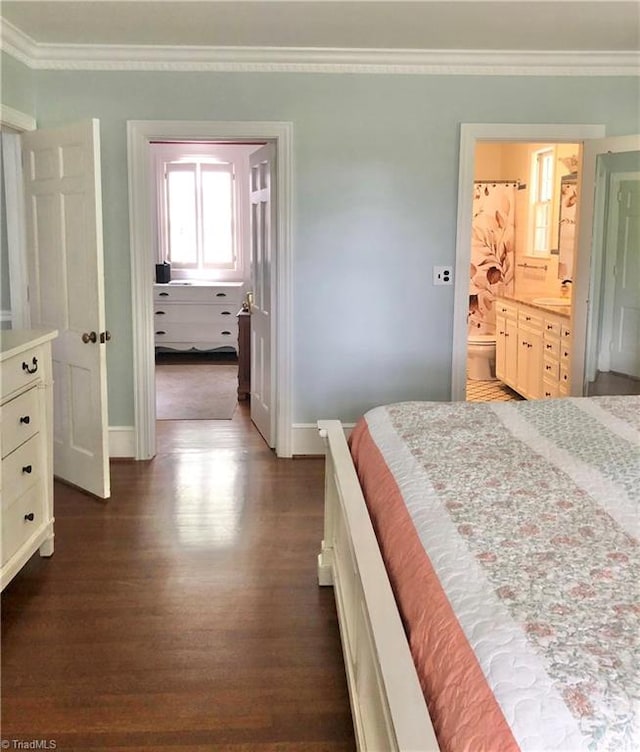 bedroom featuring ornamental molding, connected bathroom, dark wood-type flooring, and sink