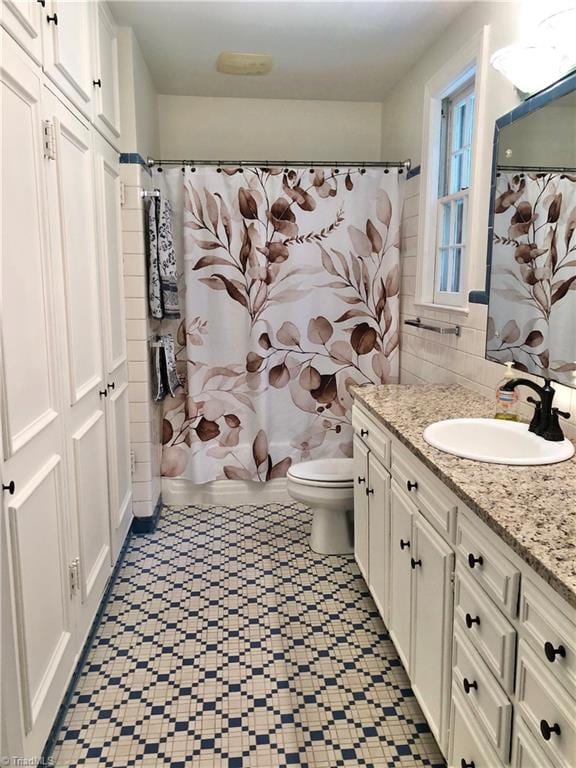 bathroom with walk in shower, vanity, and toilet