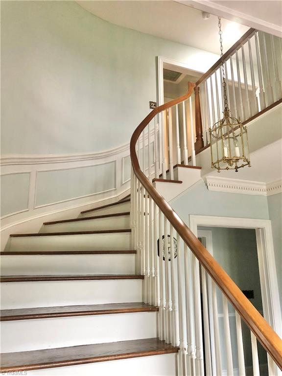 stairs with a chandelier