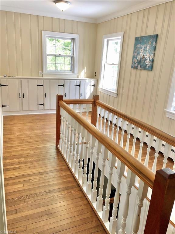 stairs featuring hardwood / wood-style flooring and crown molding