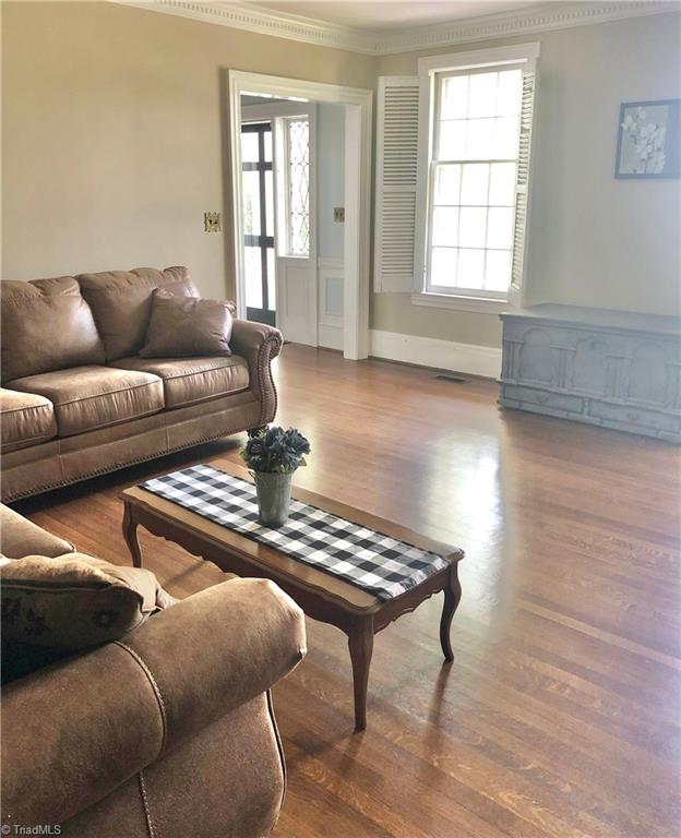 living room featuring crown molding and dark wood-type flooring