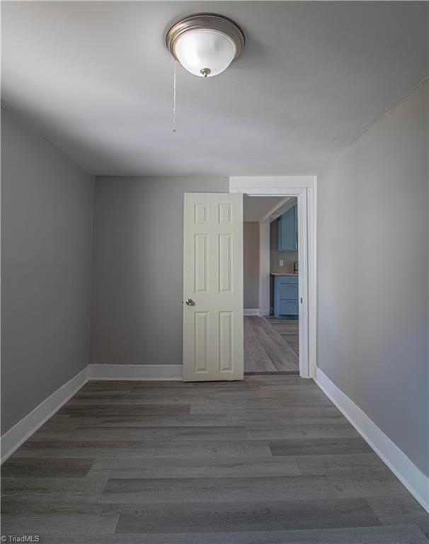 unfurnished room with dark wood-type flooring