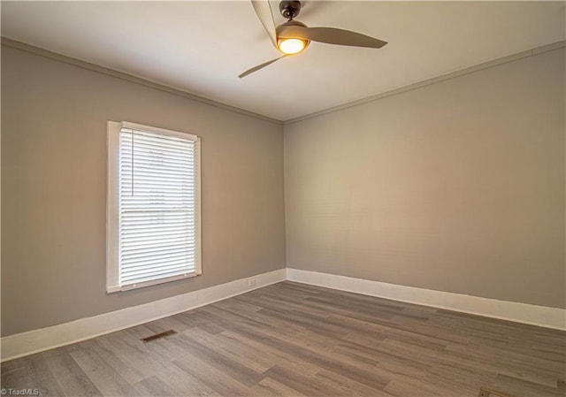 empty room featuring ceiling fan, ornamental molding, and wood-type flooring