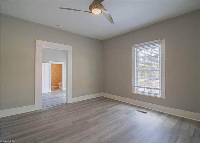 spare room featuring ceiling fan, wood-type flooring, and crown molding