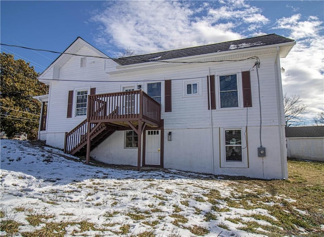 snow covered rear of property featuring a wooden deck