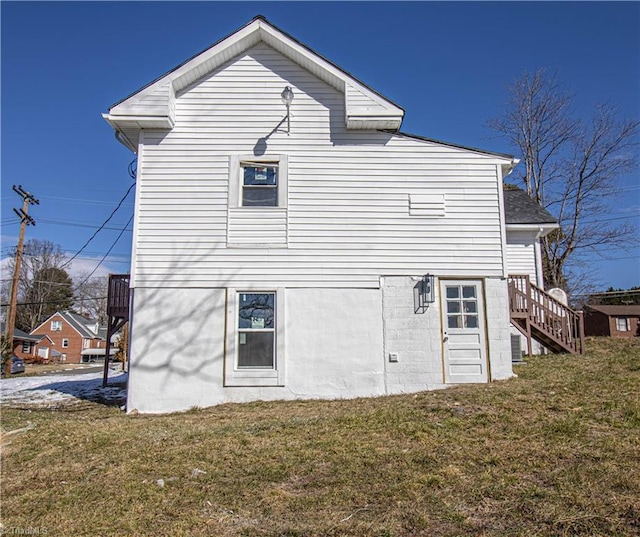 rear view of property featuring a lawn