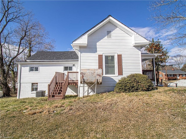 rear view of property with cooling unit and a yard