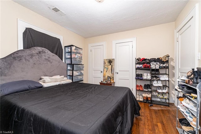 bedroom featuring wood finished floors and a textured ceiling
