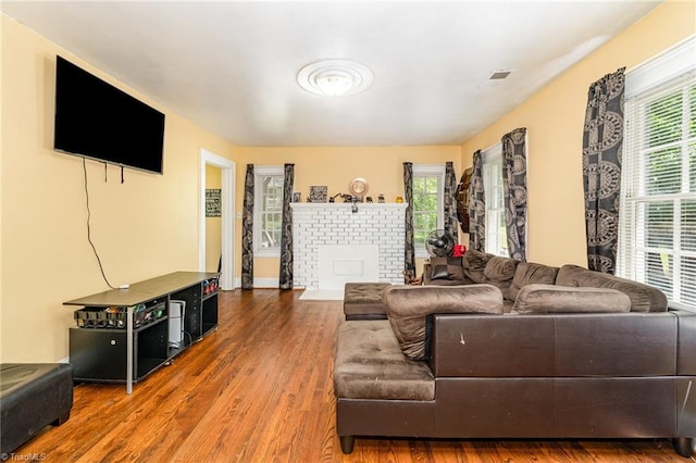 living area with wood finished floors, a fireplace, and baseboards