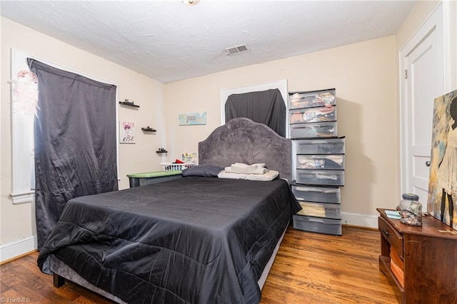 bedroom with wood finished floors and baseboards