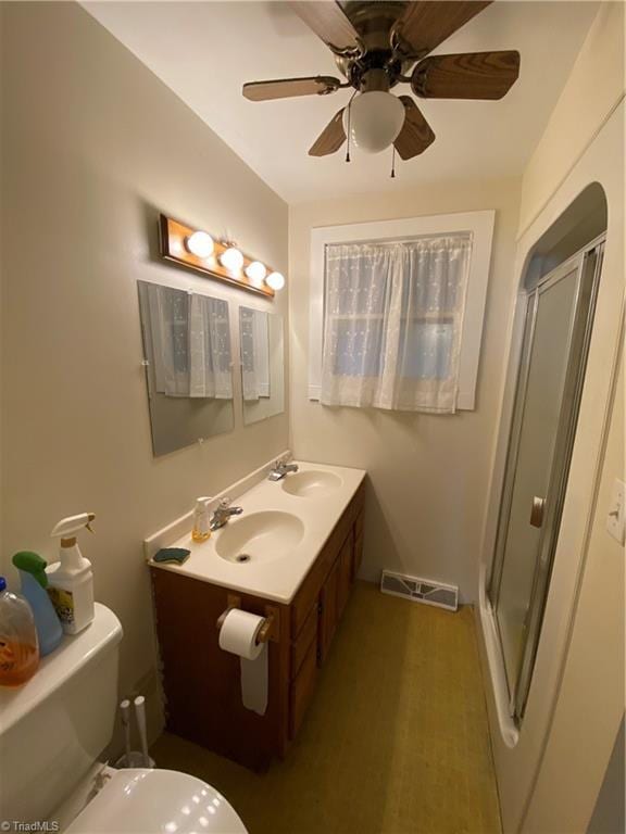 bathroom featuring vanity, ceiling fan, toilet, and walk in shower