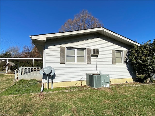 view of side of property featuring a porch, a yard, and central AC