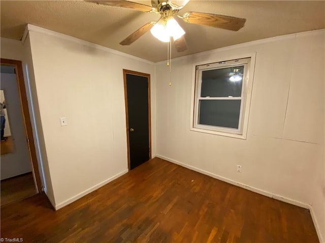 unfurnished room with ceiling fan, dark hardwood / wood-style flooring, and crown molding