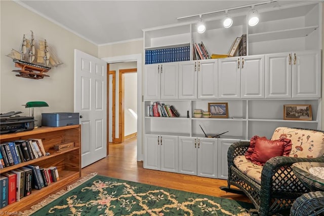 living area featuring light wood finished floors and crown molding