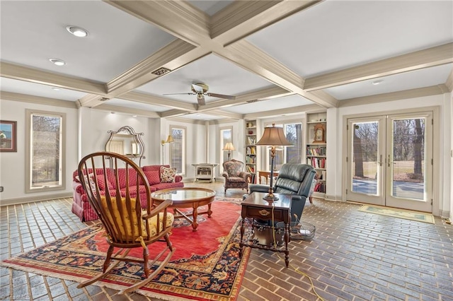 living area featuring baseboards, ornamental molding, beam ceiling, and french doors