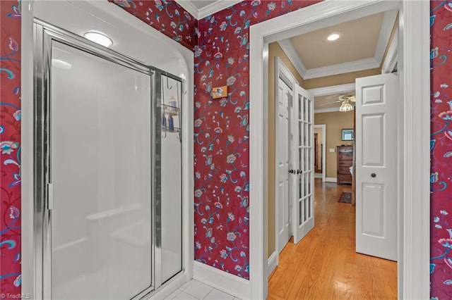 bathroom with baseboards, ornamental molding, wood finished floors, and wallpapered walls