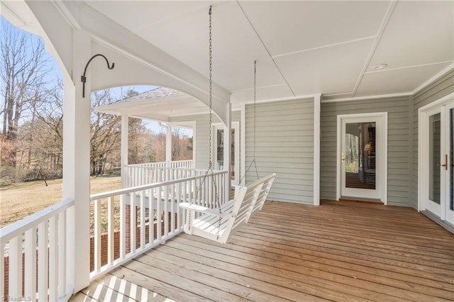 wooden terrace featuring a porch and french doors