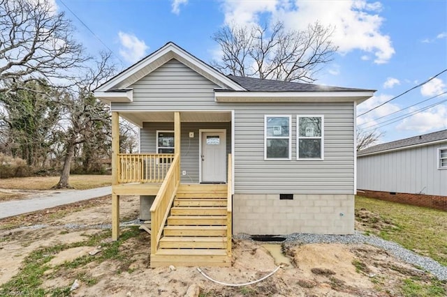 bungalow-style home with crawl space, covered porch, stairway, and roof with shingles