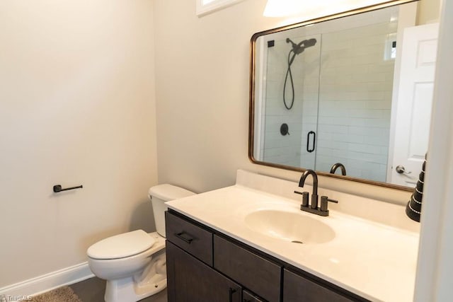 bathroom with vanity, a shower with shower door, and toilet