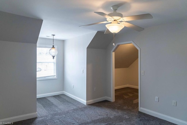 additional living space with lofted ceiling, ceiling fan, and dark colored carpet