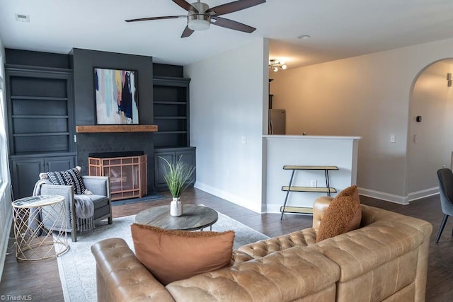 living room with dark wood-type flooring and ceiling fan