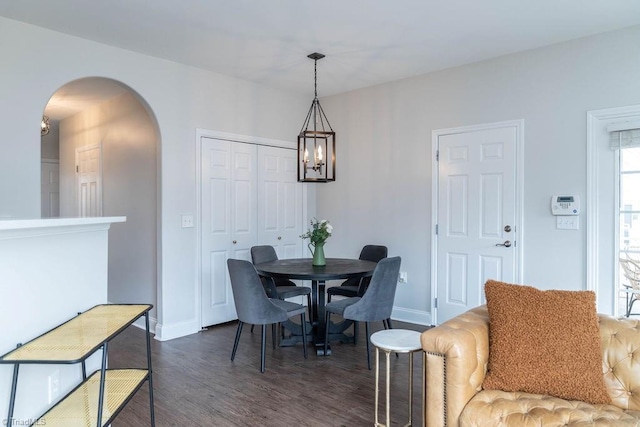 dining area featuring an inviting chandelier, dark hardwood / wood-style floors, and a wealth of natural light