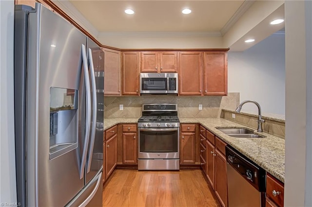 kitchen with kitchen peninsula, light stone countertops, sink, and stainless steel appliances