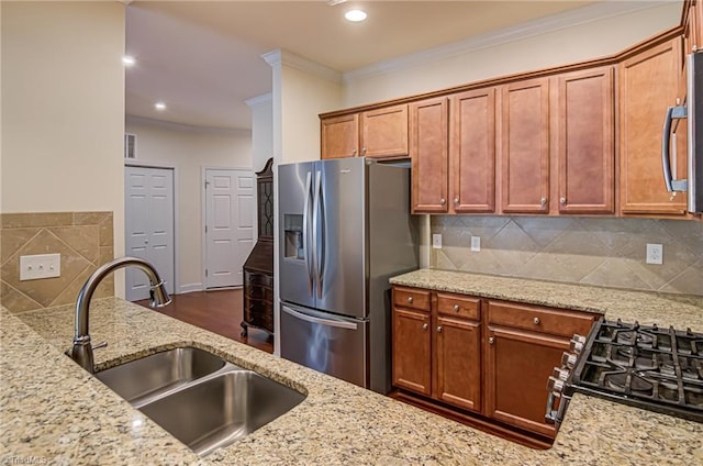 kitchen with light stone counters, sink, appliances with stainless steel finishes, and tasteful backsplash