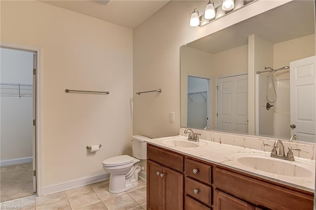 bathroom with tile patterned flooring, vanity, toilet, and walk in shower