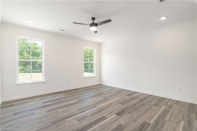 unfurnished room with crown molding, a healthy amount of sunlight, wood-type flooring, and ceiling fan