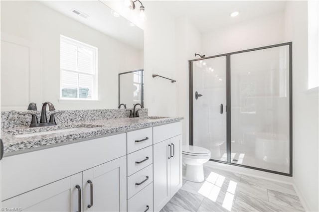 bathroom with vanity, a shower with shower door, and toilet