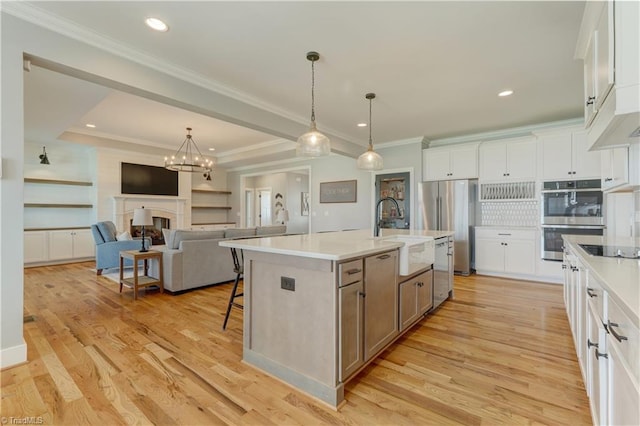 kitchen featuring stainless steel appliances, a sink, light countertops, a kitchen bar, and crown molding